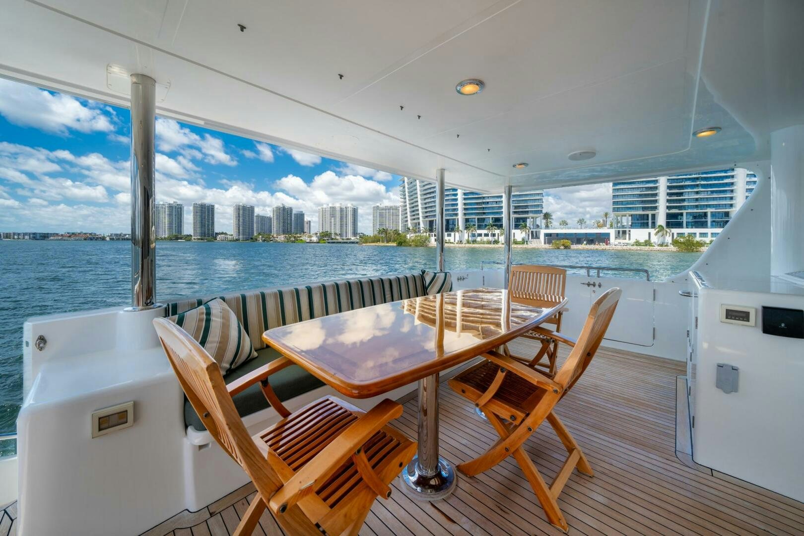 a table and chairs on a deck overlooking a city aboard BAD-LAD Yacht for Sale