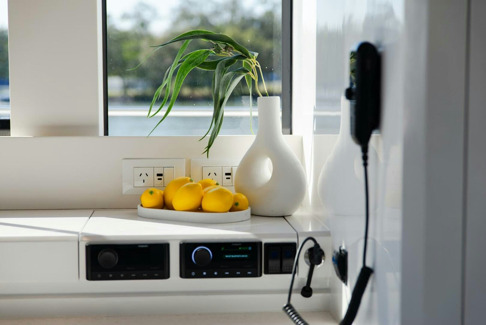 a white kitchen counter with a white vase and fruit on it aboard NONE Yacht for Sale