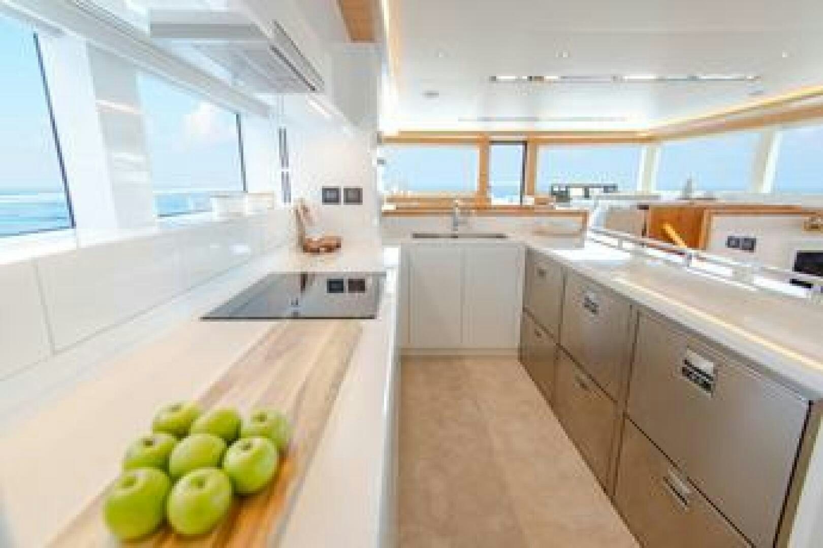 a kitchen with white cabinets and a countertop with green apples aboard NONE Yacht for Sale