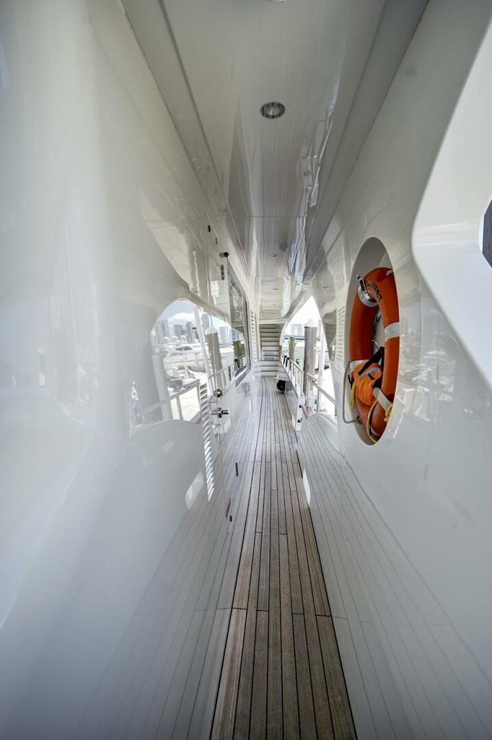 a long hallway with a red door aboard SWEET CAROLINE Yacht for Sale