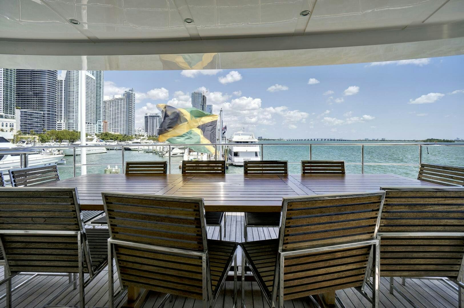 a deck with chairs and a table with a large umbrella on it aboard SWEET CAROLINE Yacht for Sale