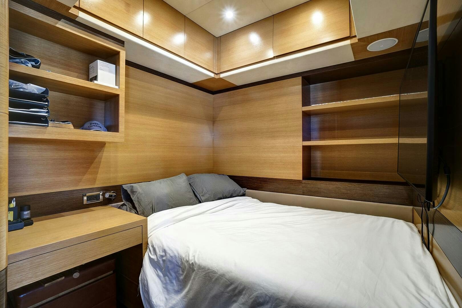 a bed with a white sheet and a wooden shelf aboard SWEET CAROLINE Yacht for Sale
