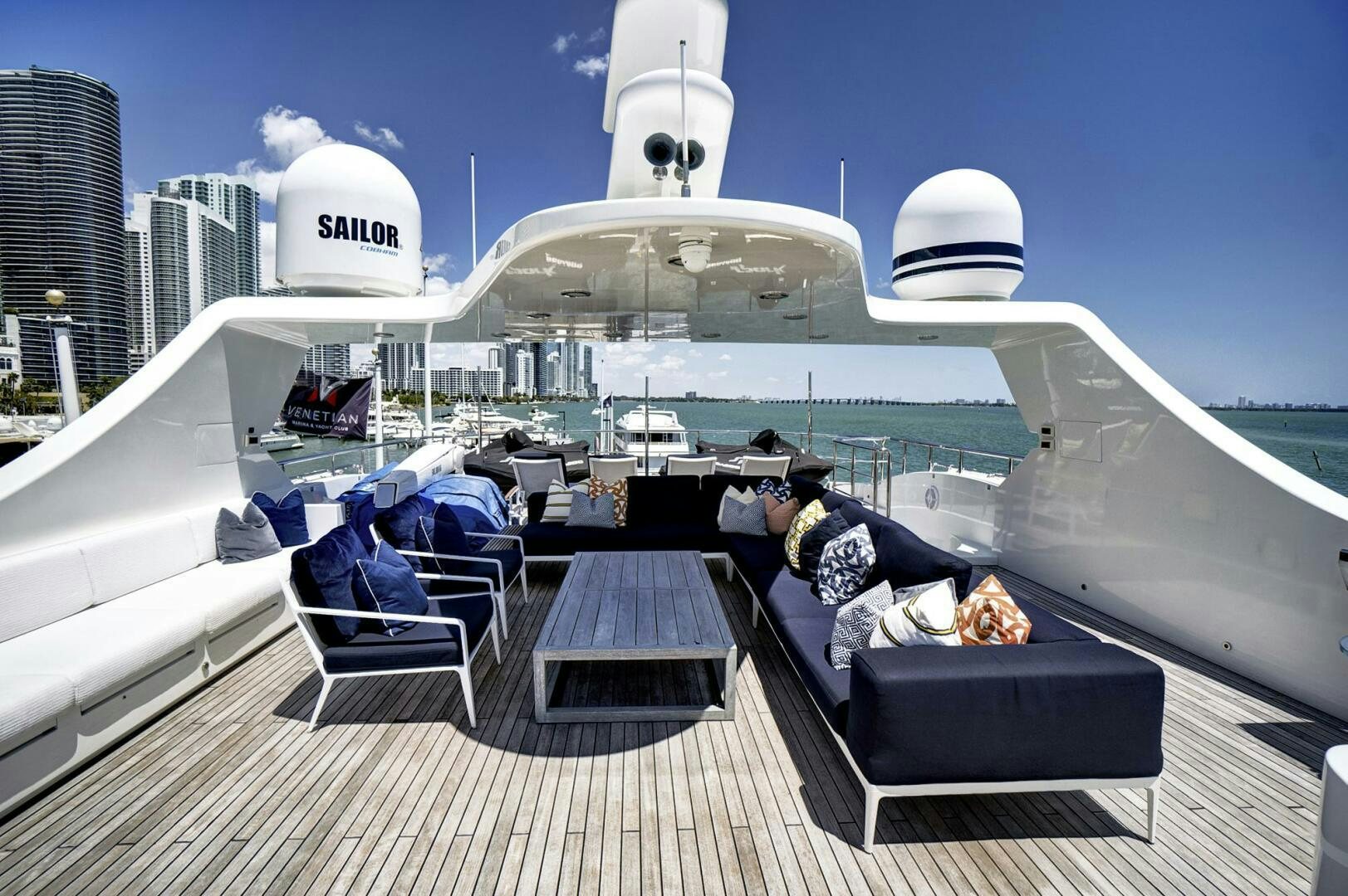 a person sitting on a bench on a deck with a large ship in the background aboard SWEET CAROLINE Yacht for Sale