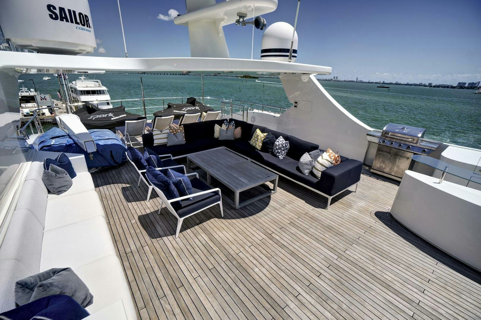 a deck with a table and chairs on it by the water aboard SWEET CAROLINE Yacht for Sale