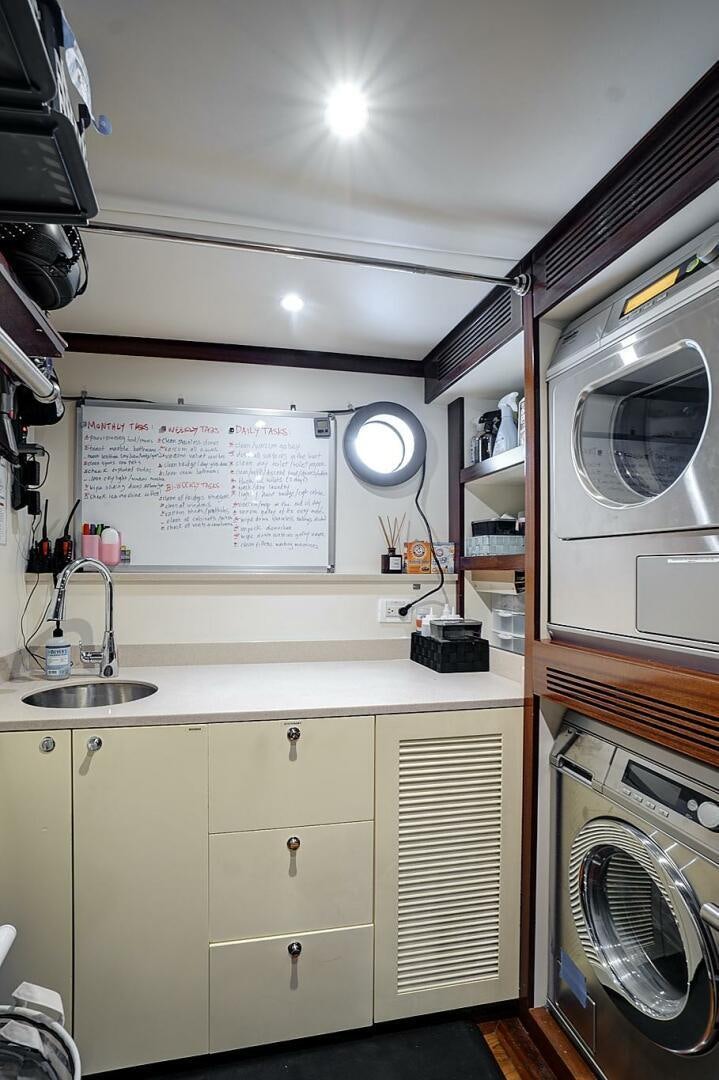 a kitchen with a washing machine and a sink aboard SWEET CAROLINE Yacht for Sale