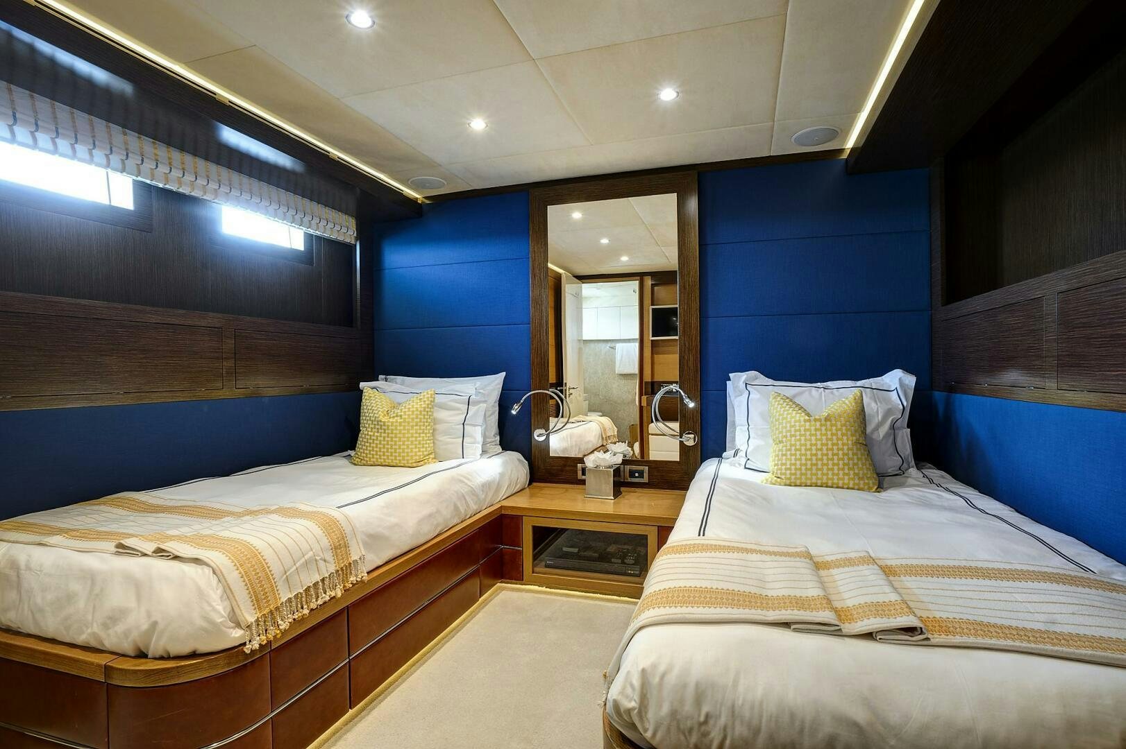 a room with blue walls and a couple of beds aboard SWEET CAROLINE Yacht for Sale