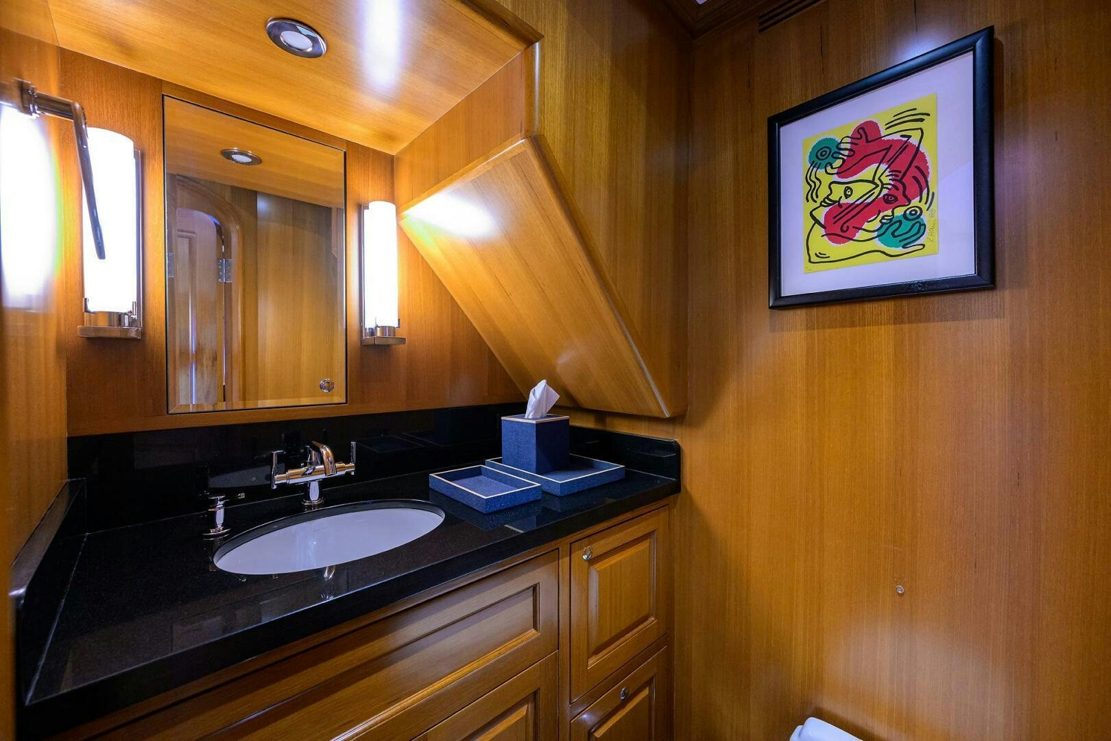 a bathroom with a sink and a painting on the wall aboard SOLACE Yacht for Sale