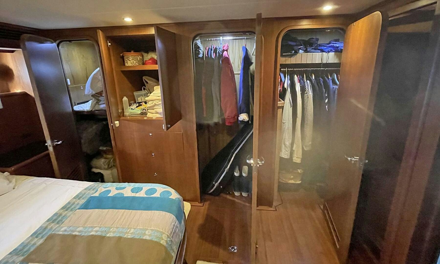 a closet with clothes on the wall aboard BRAVO! Yacht for Sale