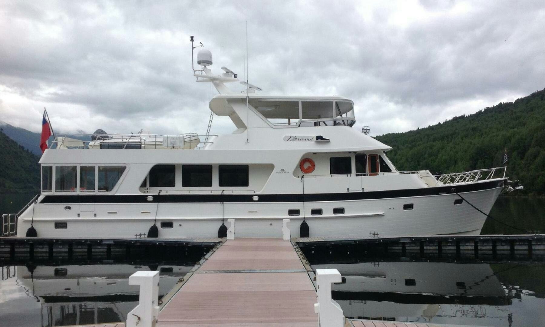 a large white boat on a dock aboard BRAVO! Yacht for Sale