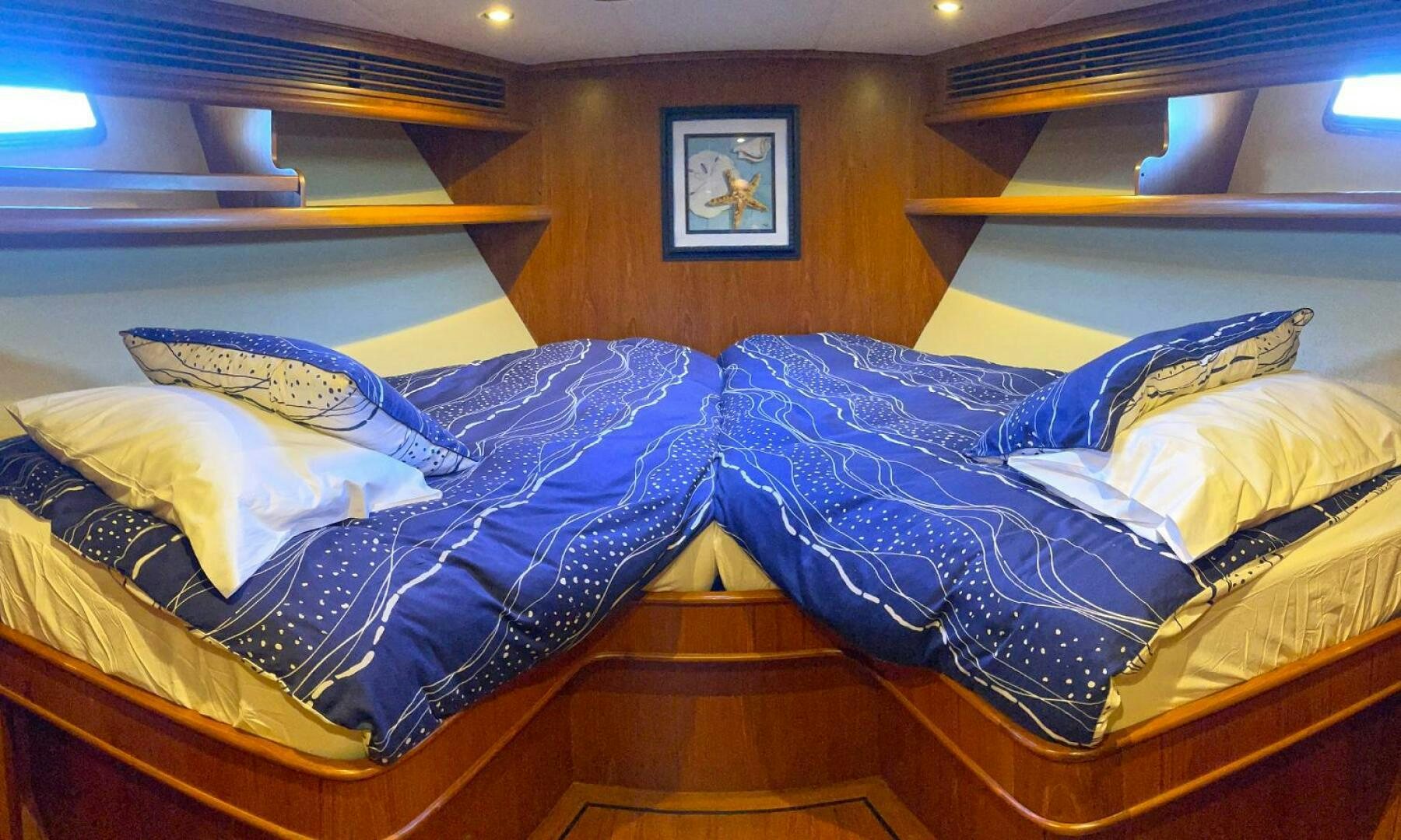 a bed with blue sheets aboard BRAVO! Yacht for Sale