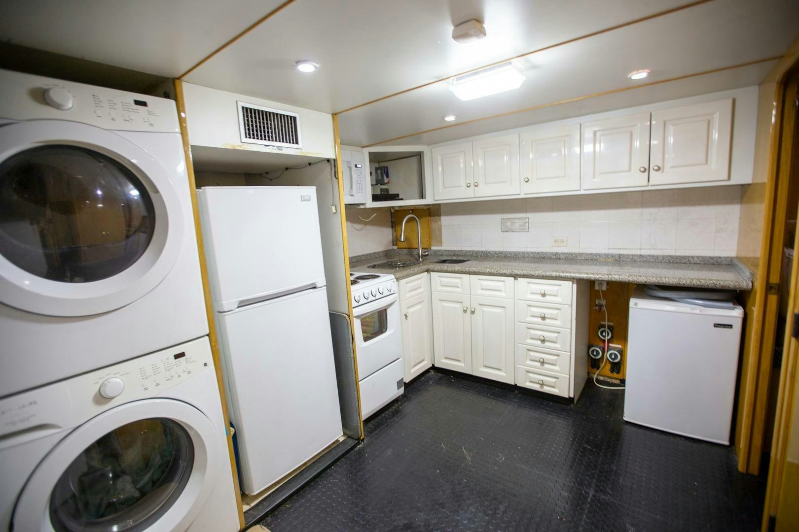 a kitchen with white cabinets aboard PAINKILLER Yacht for Sale