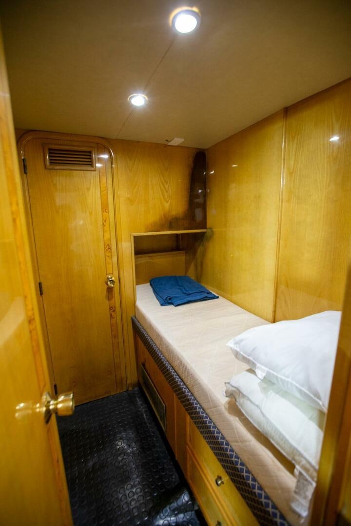 a bedroom with a bed and a closet aboard PAINKILLER Yacht for Sale