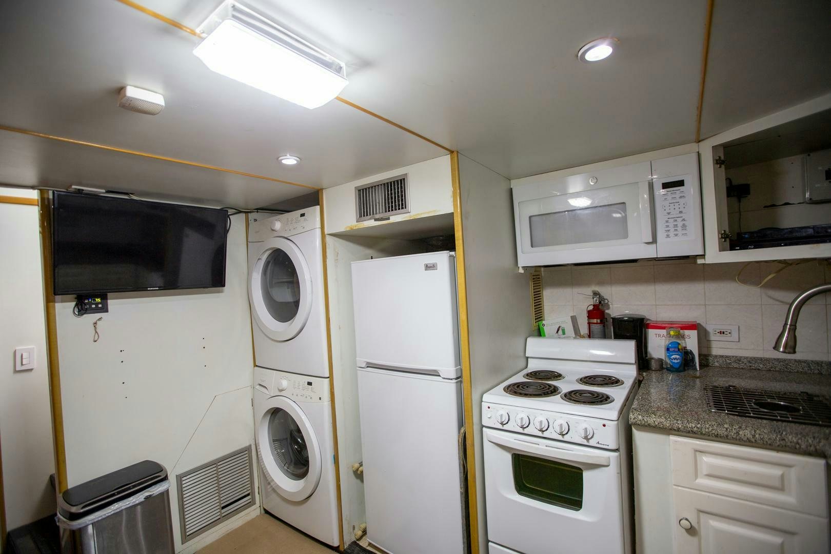 a kitchen with white appliances aboard PAINKILLER Yacht for Sale