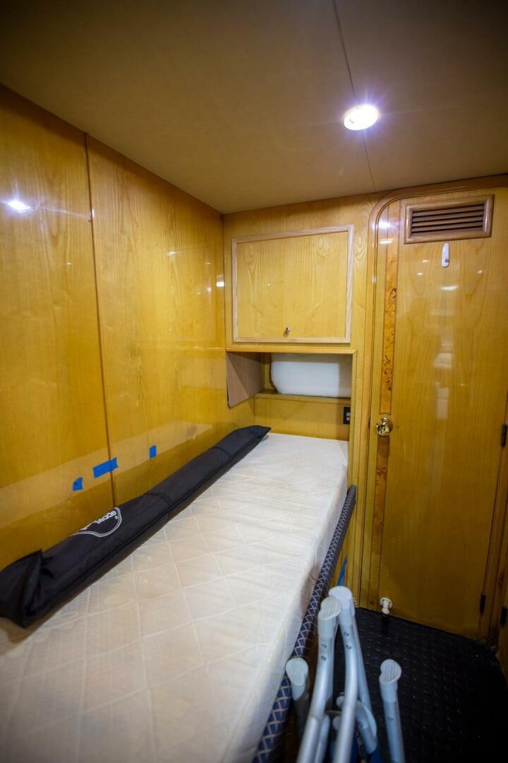 a room with a wood wall and a bed and a door aboard PAINKILLER Yacht for Sale
