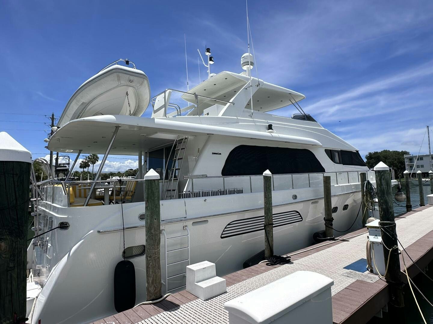 a white boat on a dock aboard RECYCLING MADE CENTS Yacht for Sale