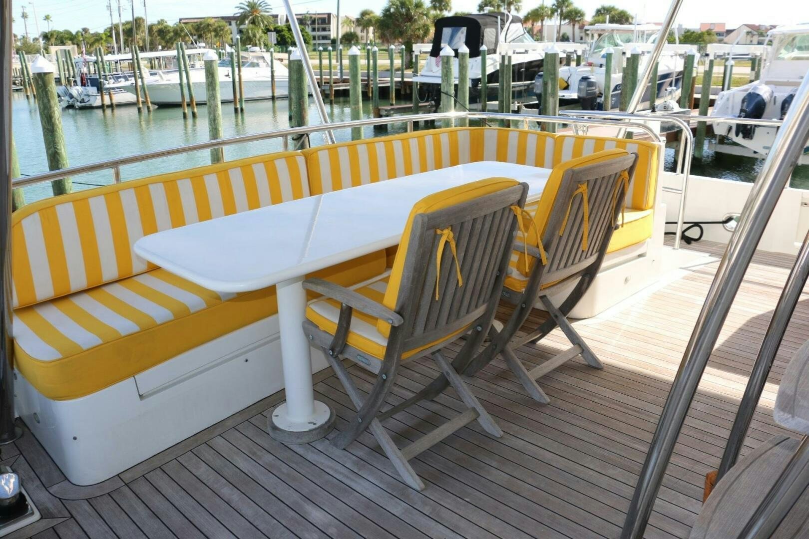 a deck with chairs and a table on it aboard RECYCLING MADE CENTS Yacht for Sale