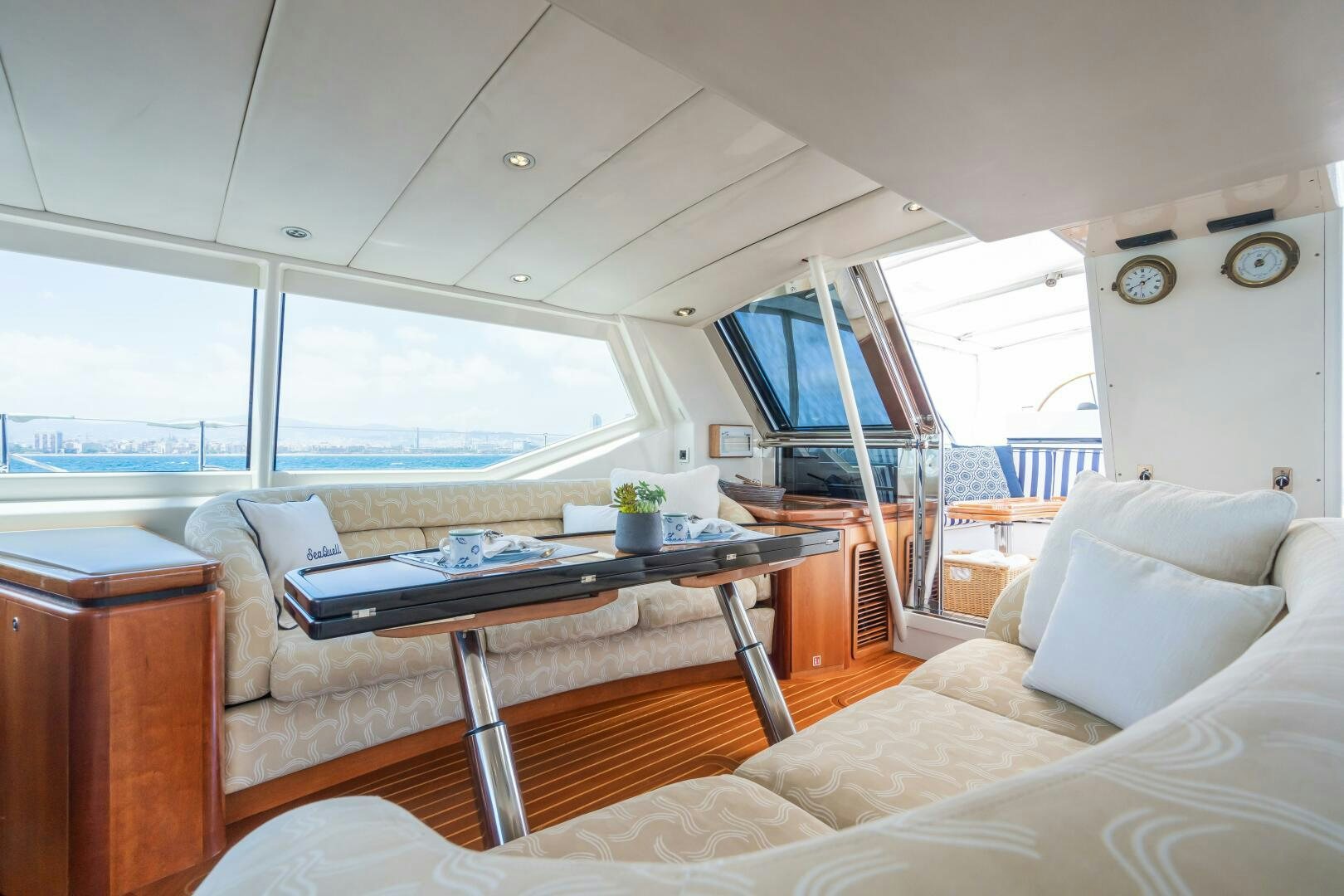 a living room with a table and couches aboard SEAQUELL Yacht for Sale