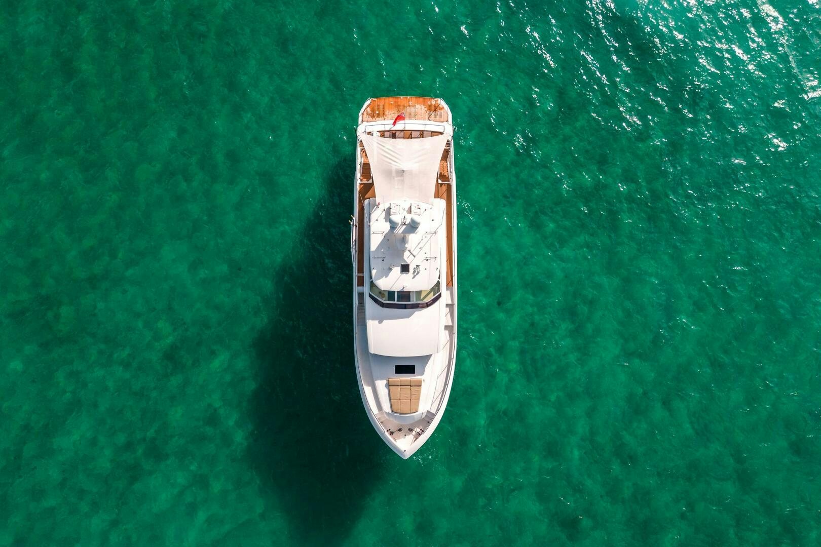 a white boat on a green surface aboard MIDNIGHT MOON Yacht for Sale