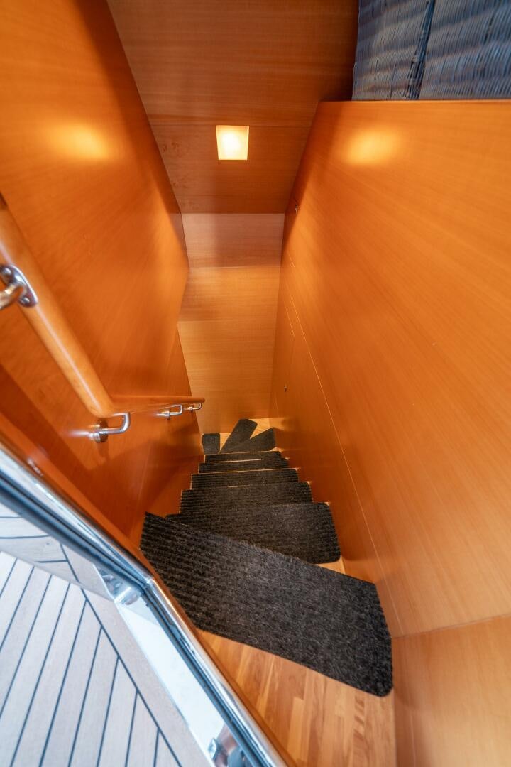a staircase with a wood railing aboard MIDNIGHT MOON Yacht for Sale