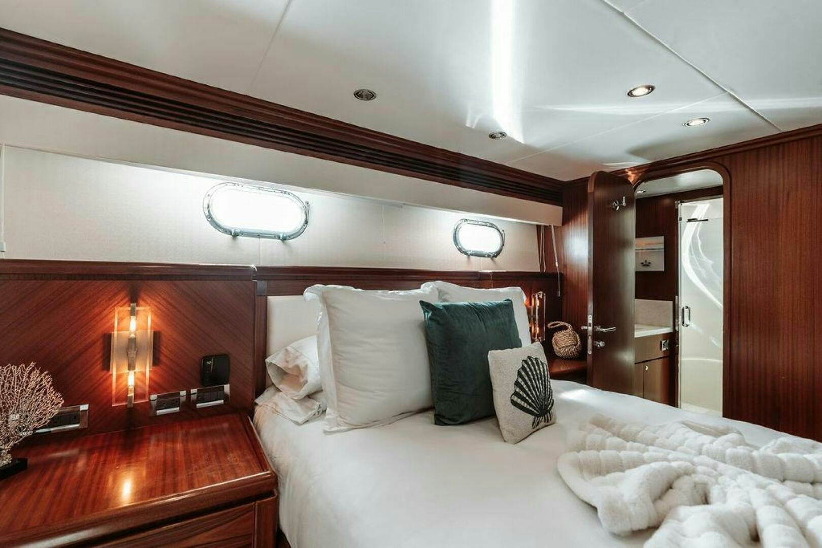 a bed with a white bed spread aboard BEACHFRONT Yacht for Sale