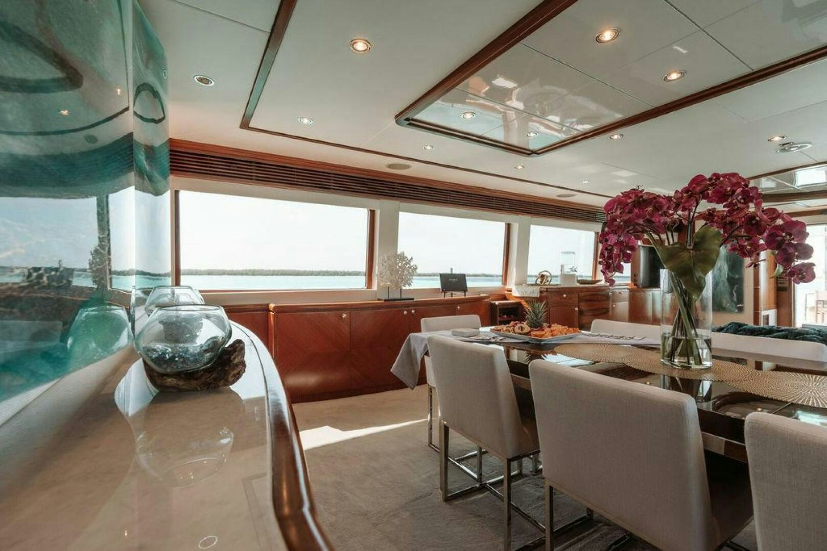 a dining room with a vase of flowers on a table aboard BEACHFRONT Yacht for Sale