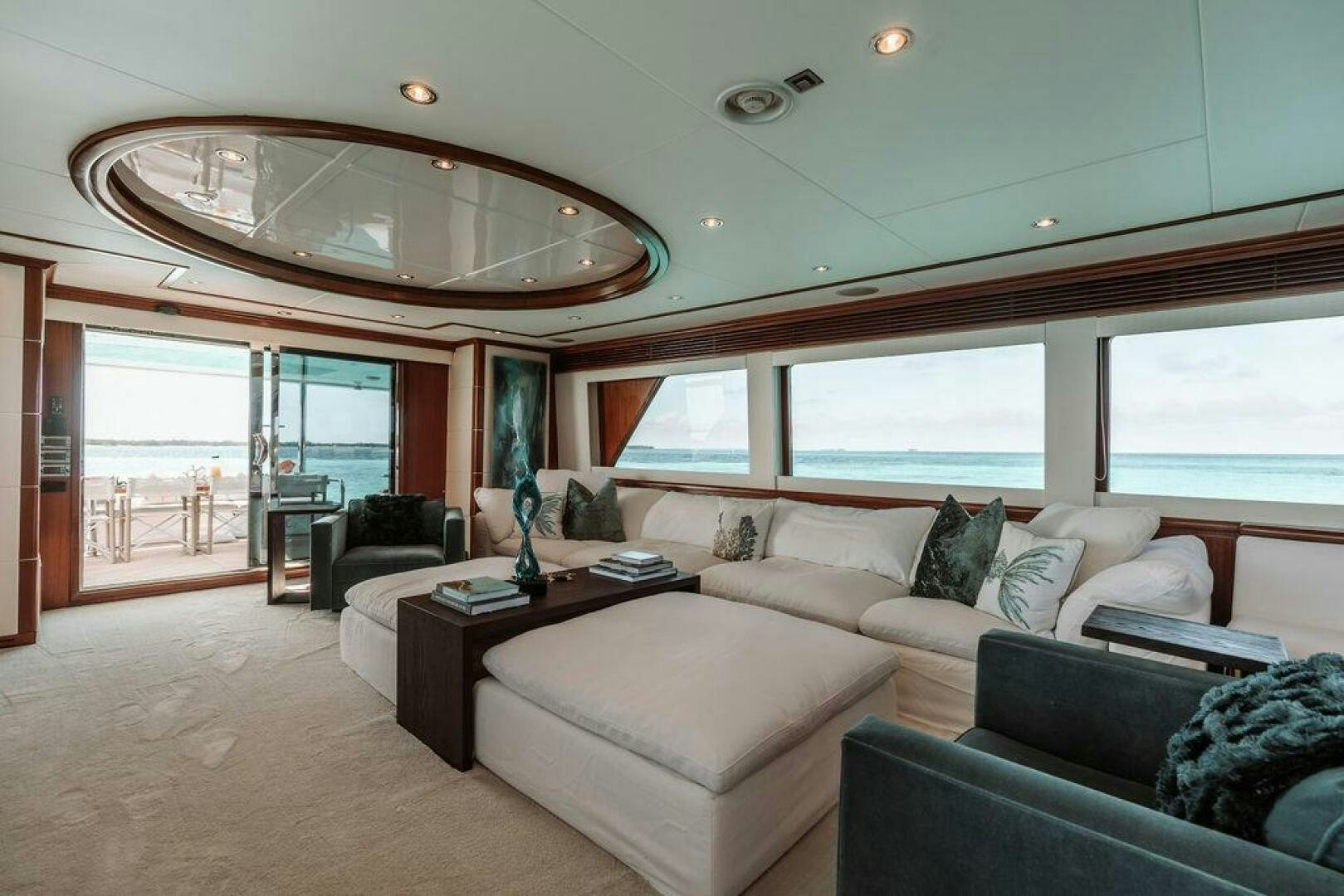 a living room with a large chandelier aboard BEACHFRONT Yacht for Sale