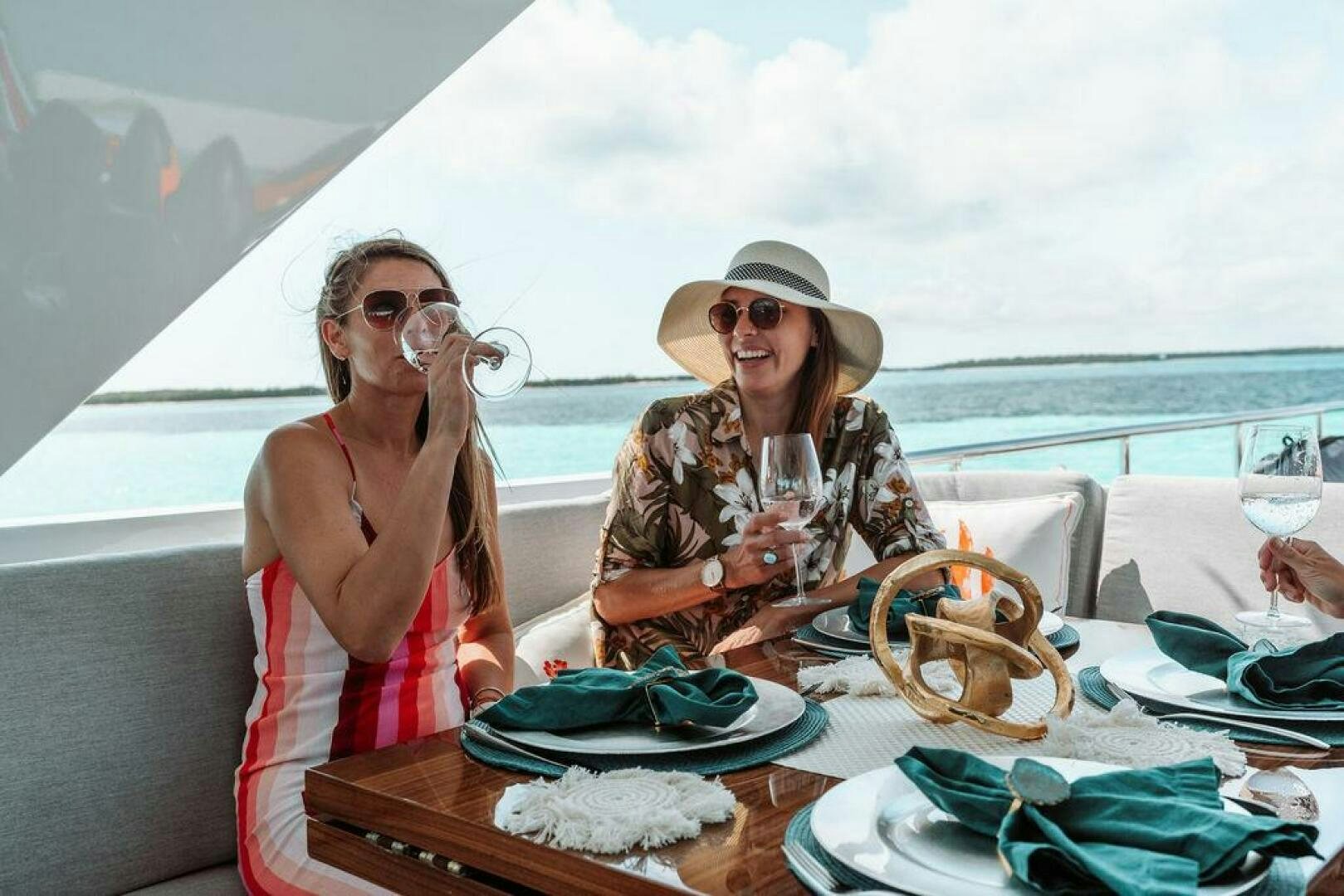 a couple of women sitting at a table with food and drinks aboard BEACHFRONT Yacht for Sale