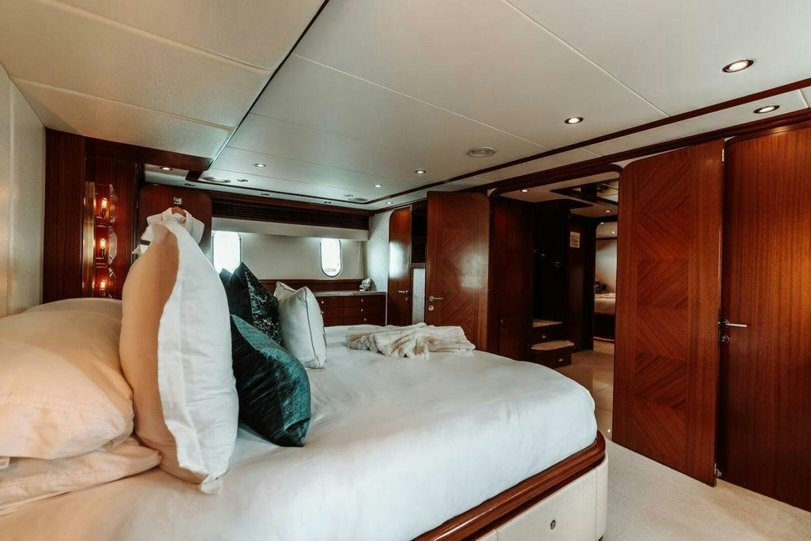 a room with a bed and a wood cabinet aboard BEACHFRONT Yacht for Sale