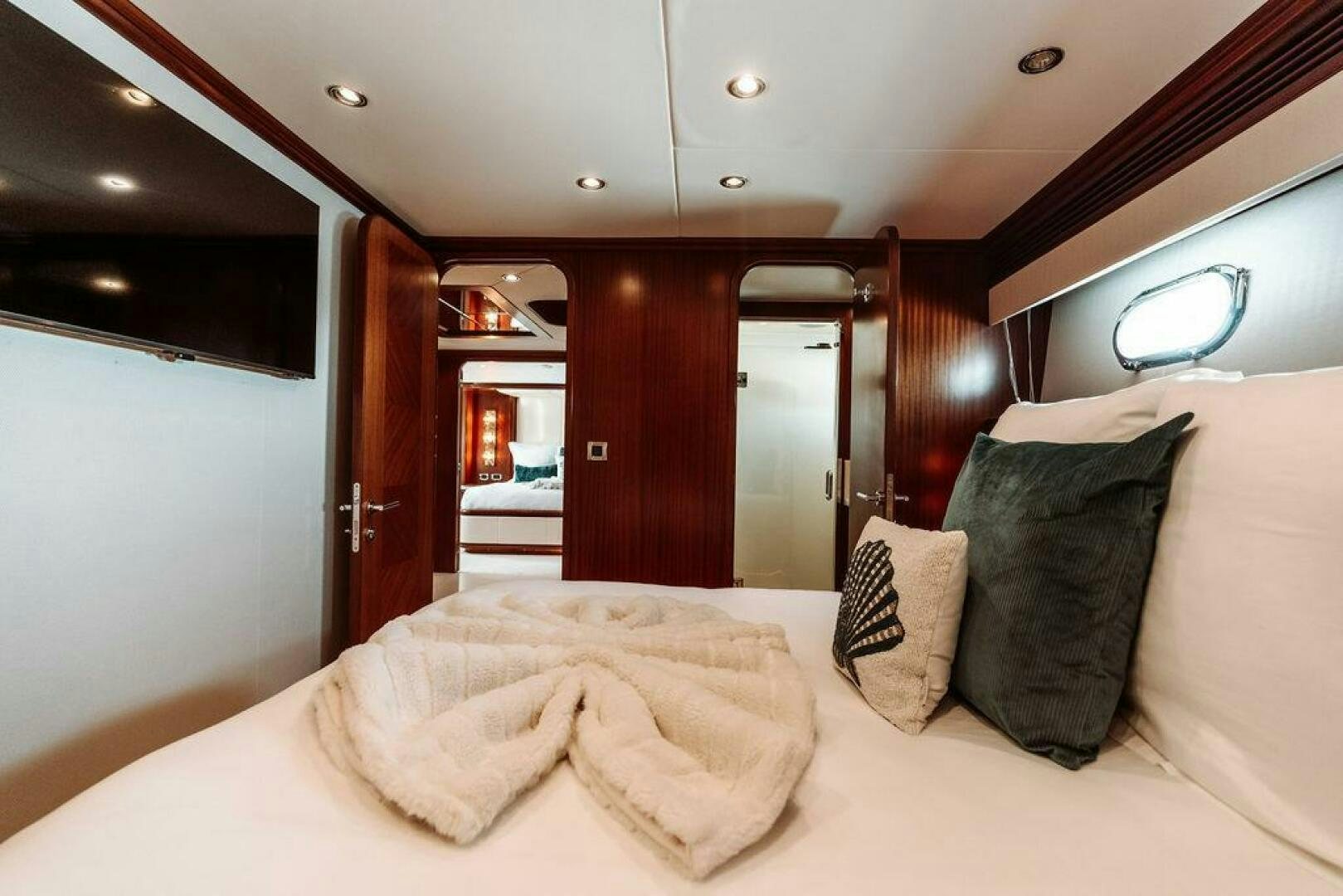 a bed with pillows and a mirror aboard BEACHFRONT Yacht for Sale