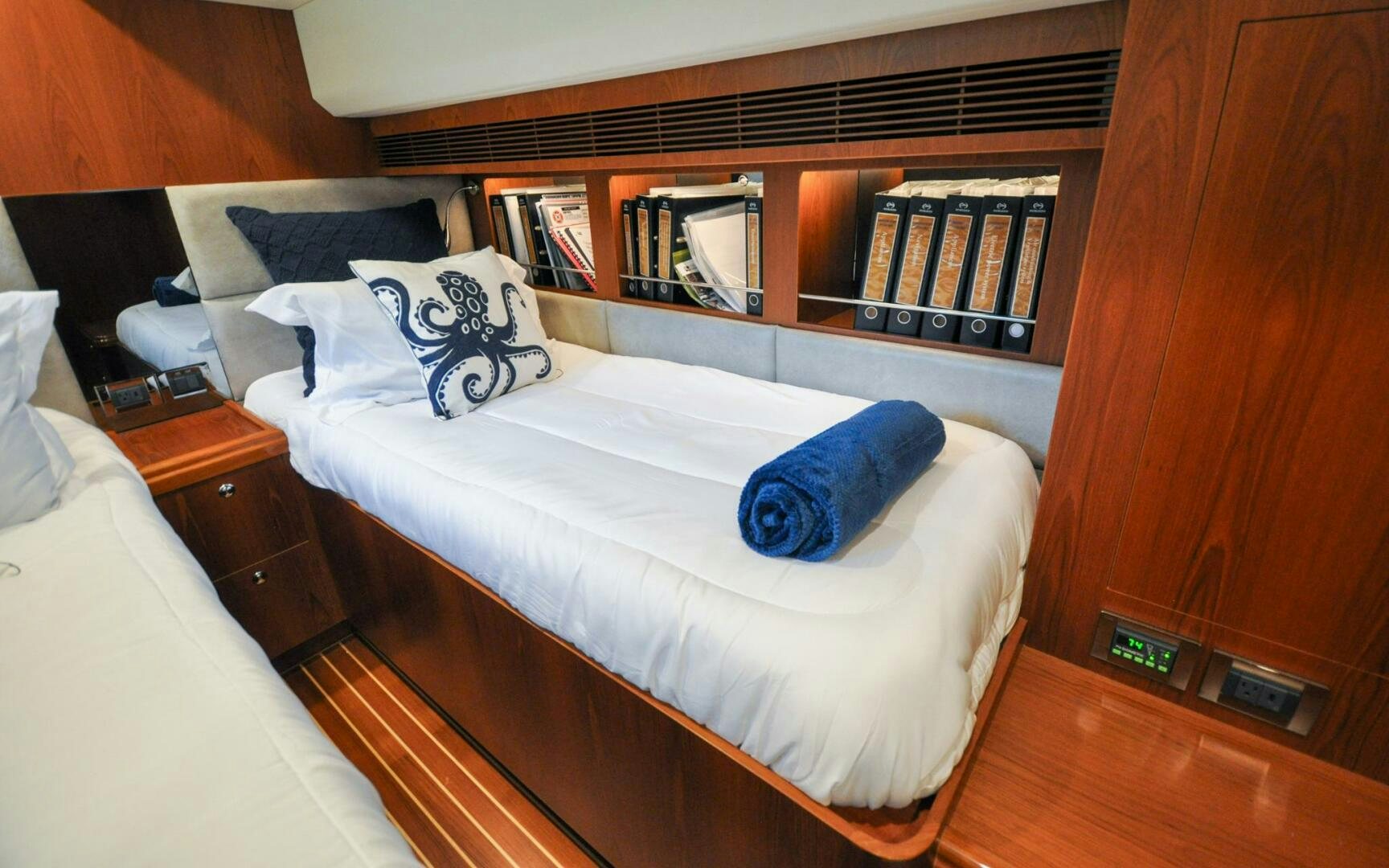a bed with blue pillows aboard CASTINA Yacht for Sale
