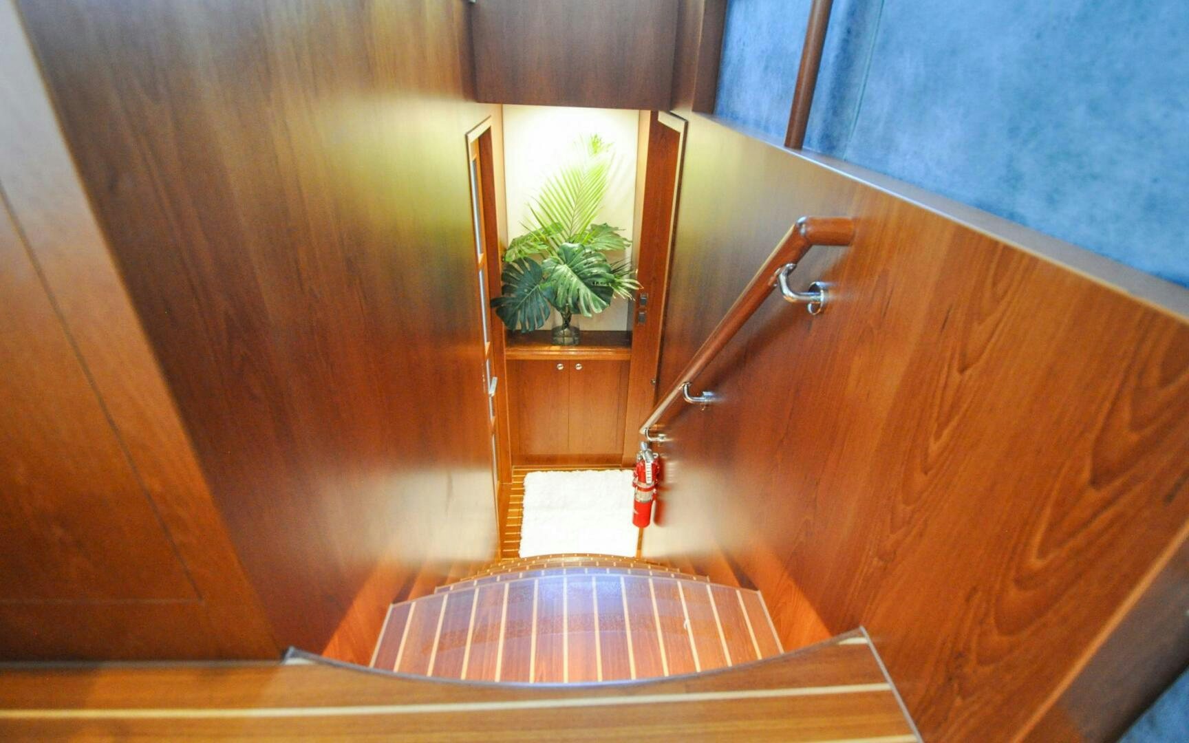 a wooden staircase with a plant on the side aboard CASTINA Yacht for Sale