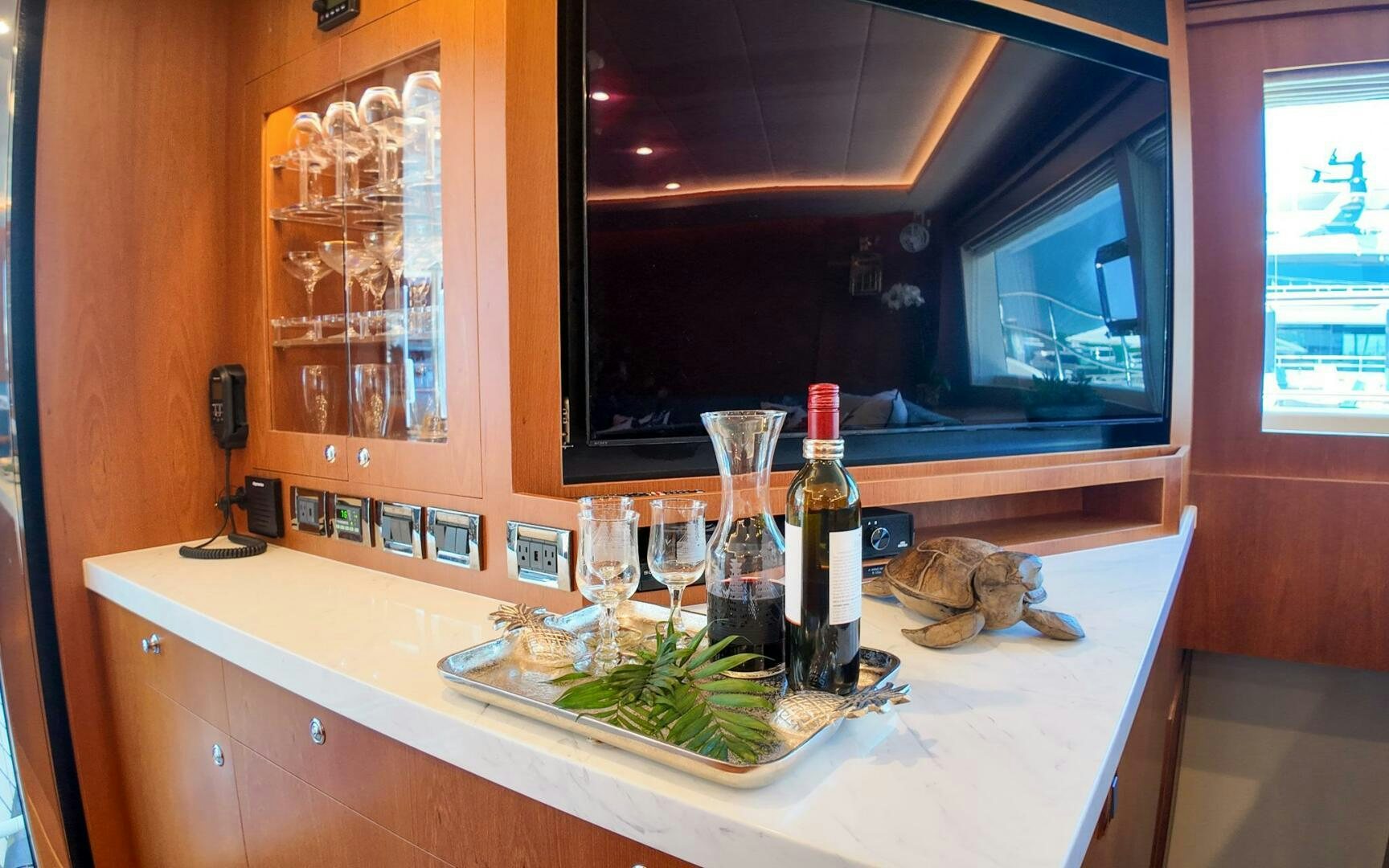 a counter with bottles and glasses on it aboard CASTINA Yacht for Sale