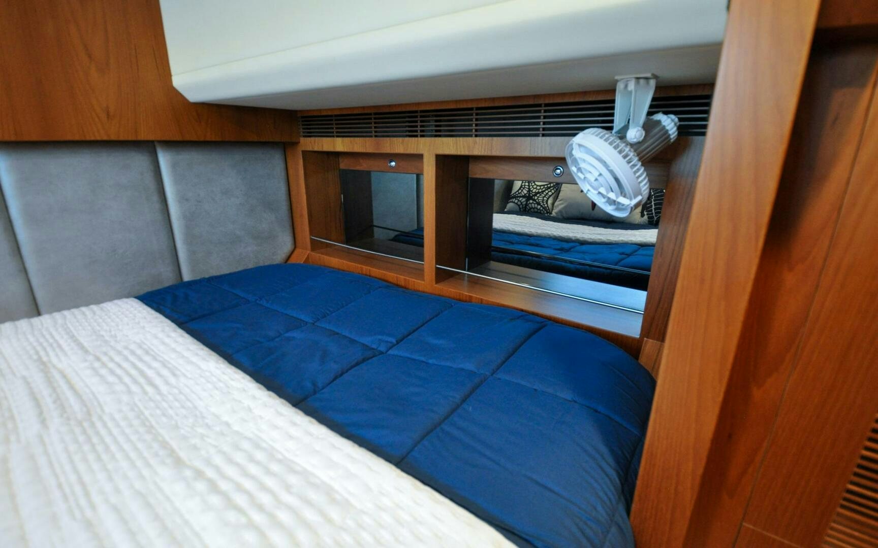 a bed with a blue sheet aboard CASTINA Yacht for Sale