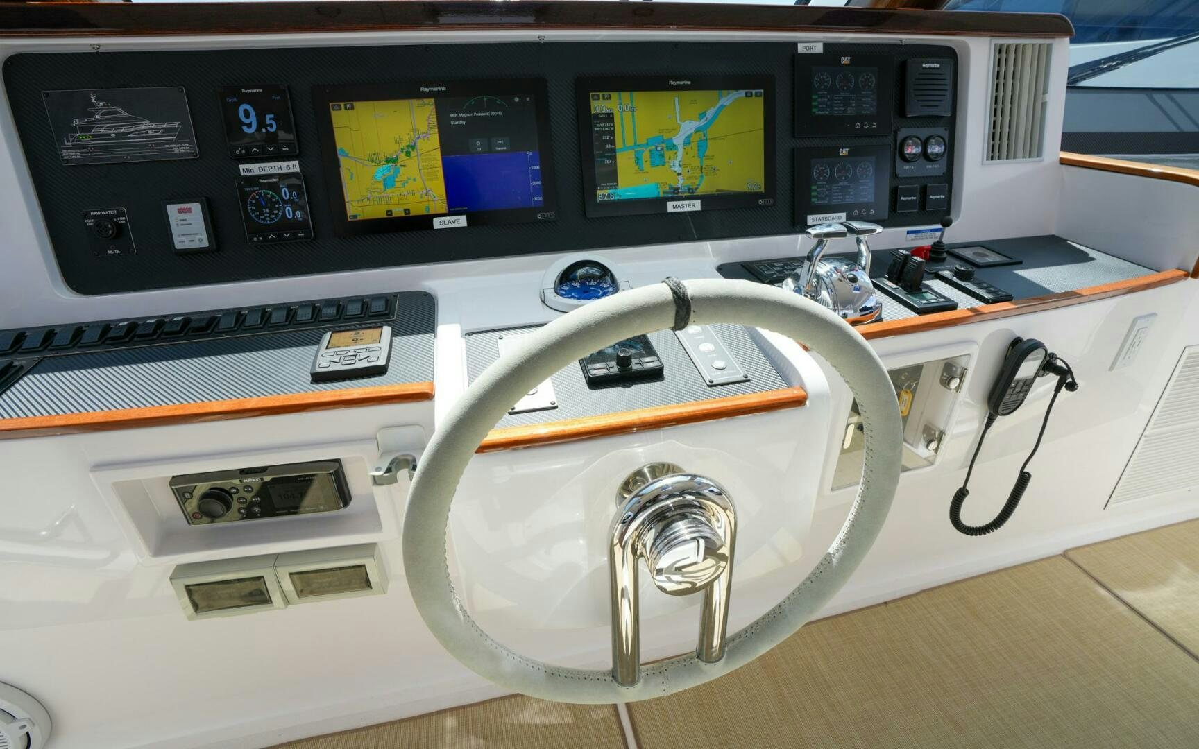 a white steering wheel in front of a computer monitor aboard CASTINA Yacht for Sale