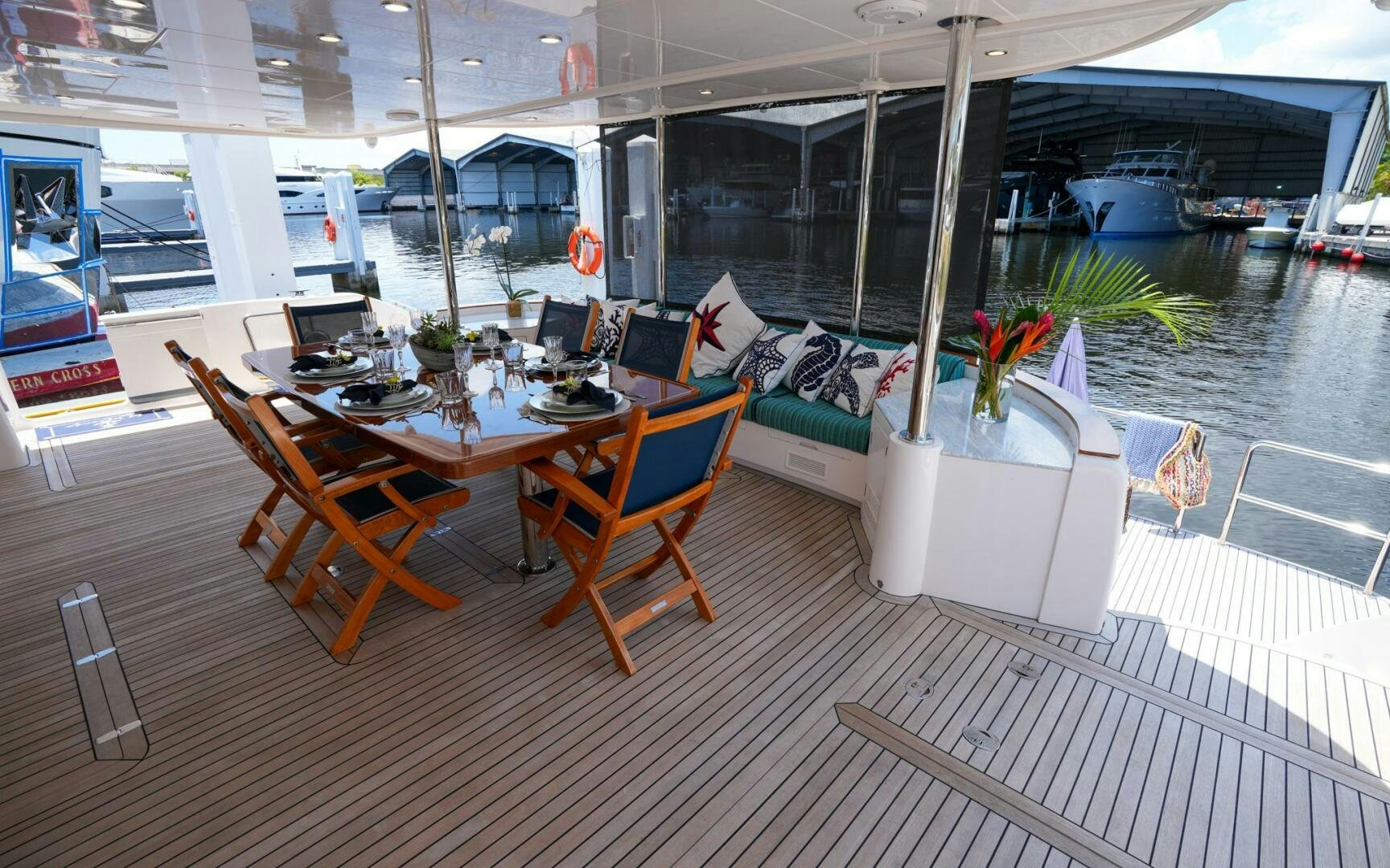 a room with a table chairs and plants on the table aboard CASTINA Yacht for Sale
