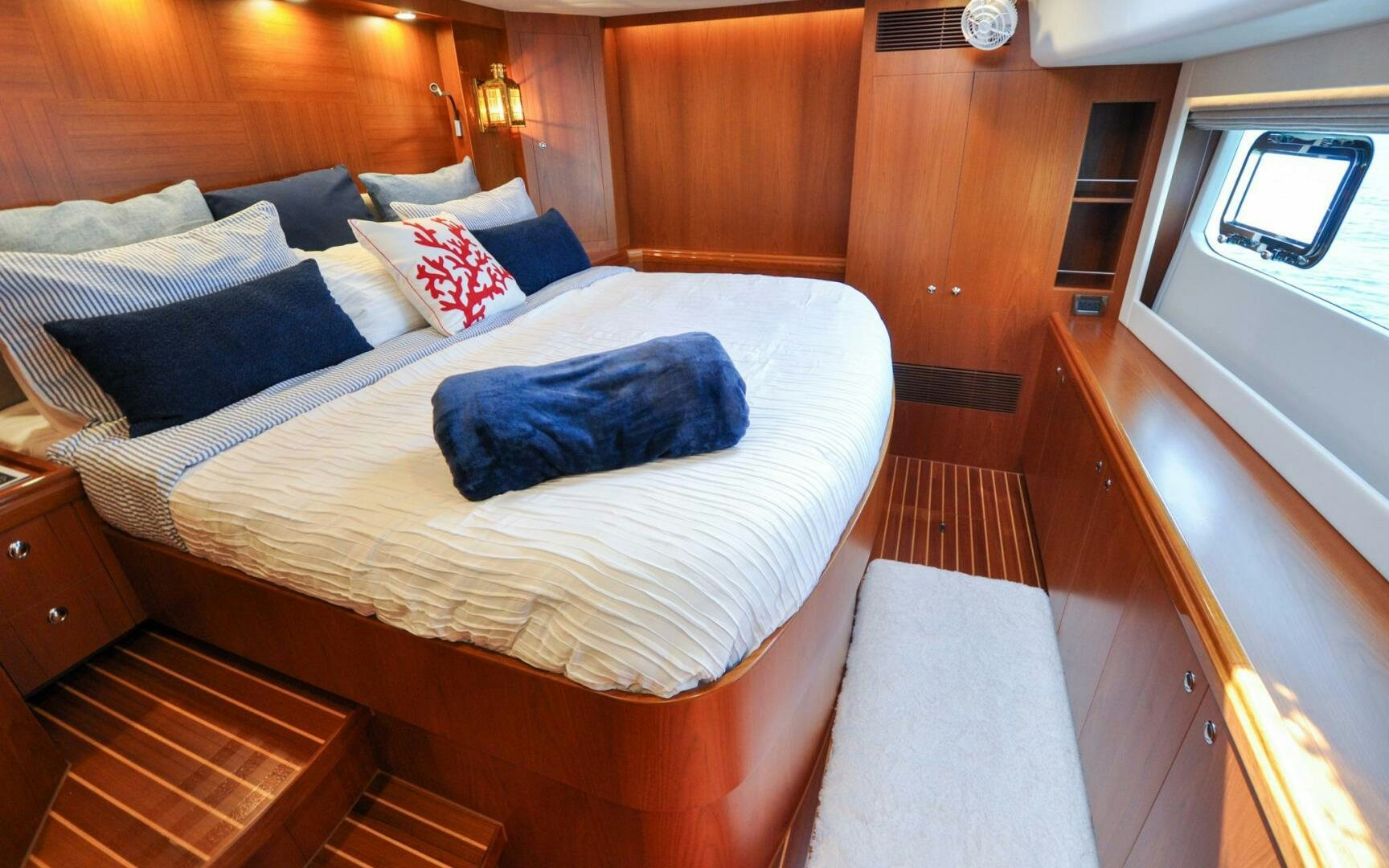a bed with blue pillows aboard CASTINA Yacht for Sale