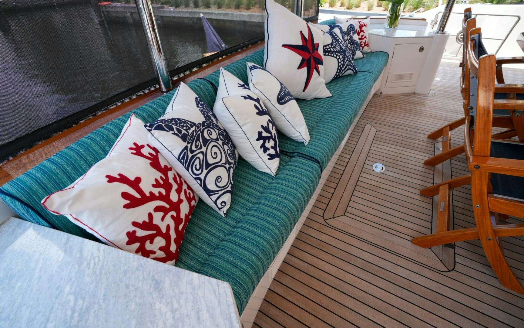 a bed with pillows and a chair aboard CASTINA Yacht for Sale