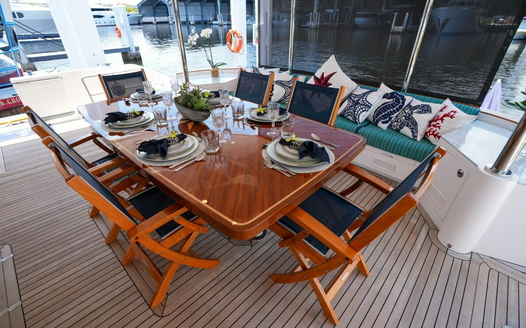 a table with plates and chairs on it aboard CASTINA Yacht for Sale