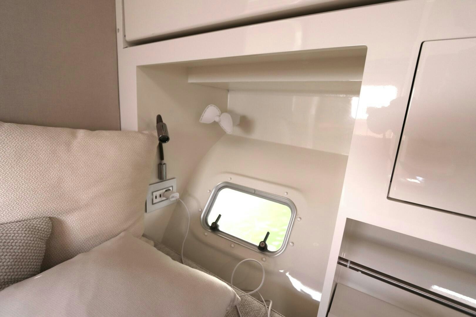 a bed with a white bed and a white wall with a mirror aboard CATCH ME Yacht for Sale