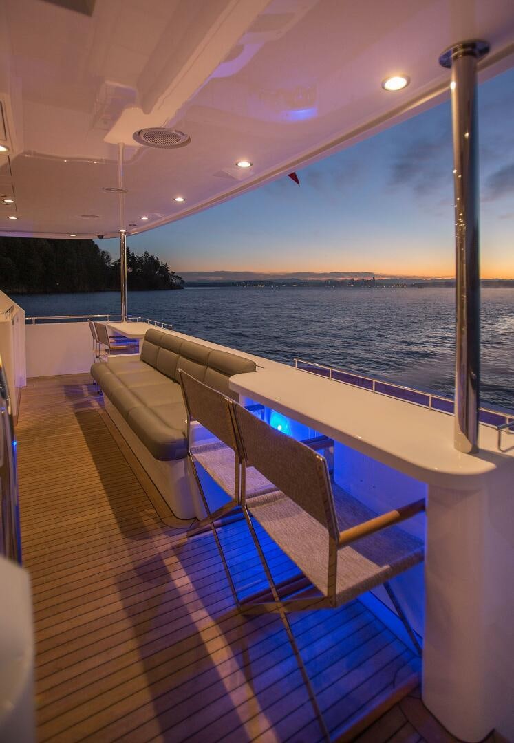 a deck with a view of the water and the land below aboard CAZADOR Yacht for Sale
