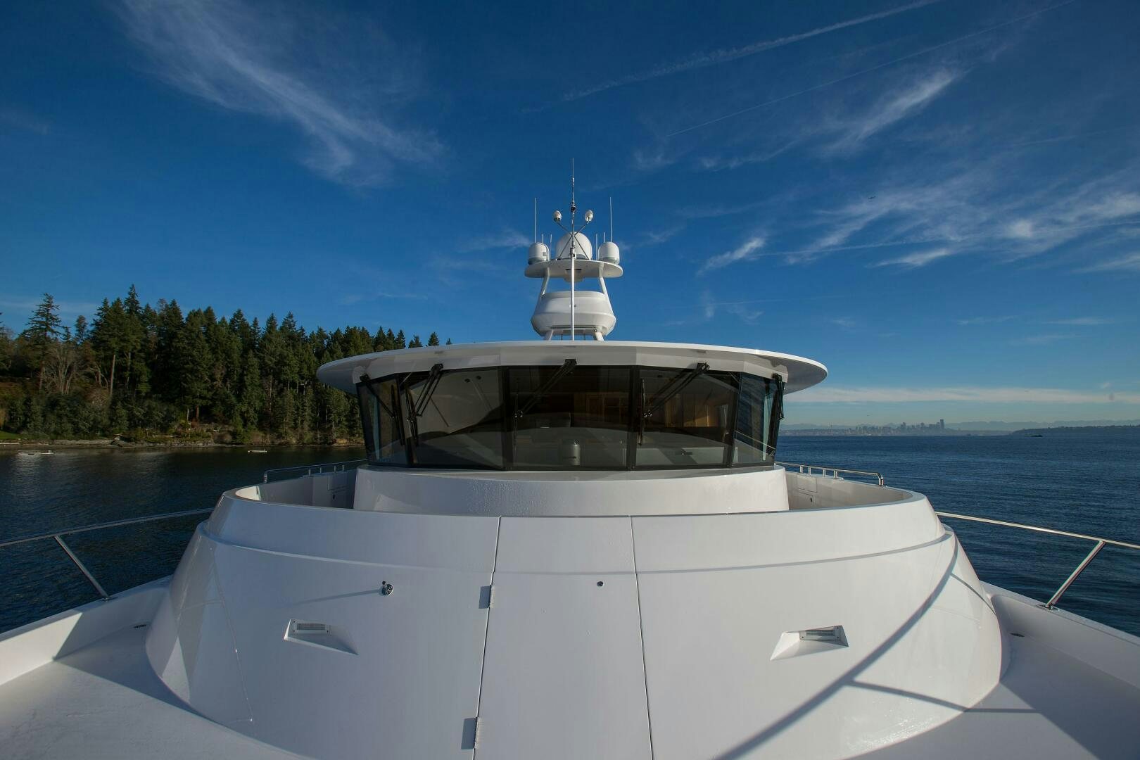 a white boat on a body of water with trees in the background aboard CAZADOR Yacht for Sale