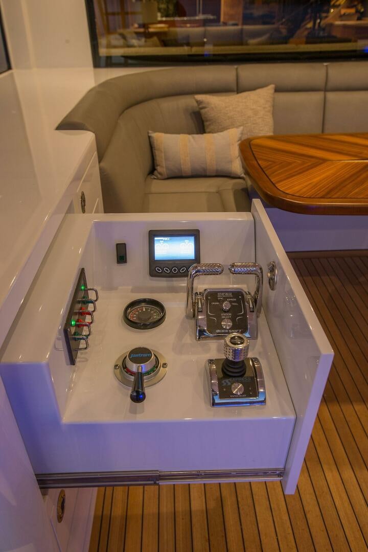 a table with a laptop and a game controller on it aboard CAZADOR Yacht for Sale