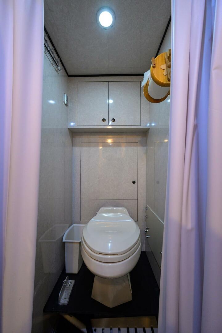 a bathroom with a toilet and a shower curtain aboard JR Yacht for Sale
