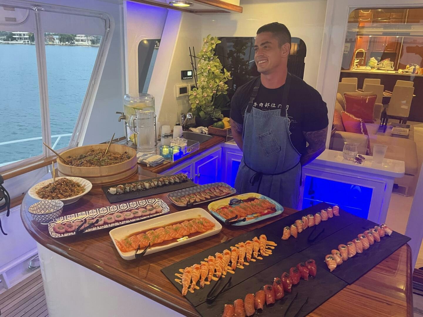 a person standing next to a table full of food aboard PRECIOUS CARGO Yacht for Sale