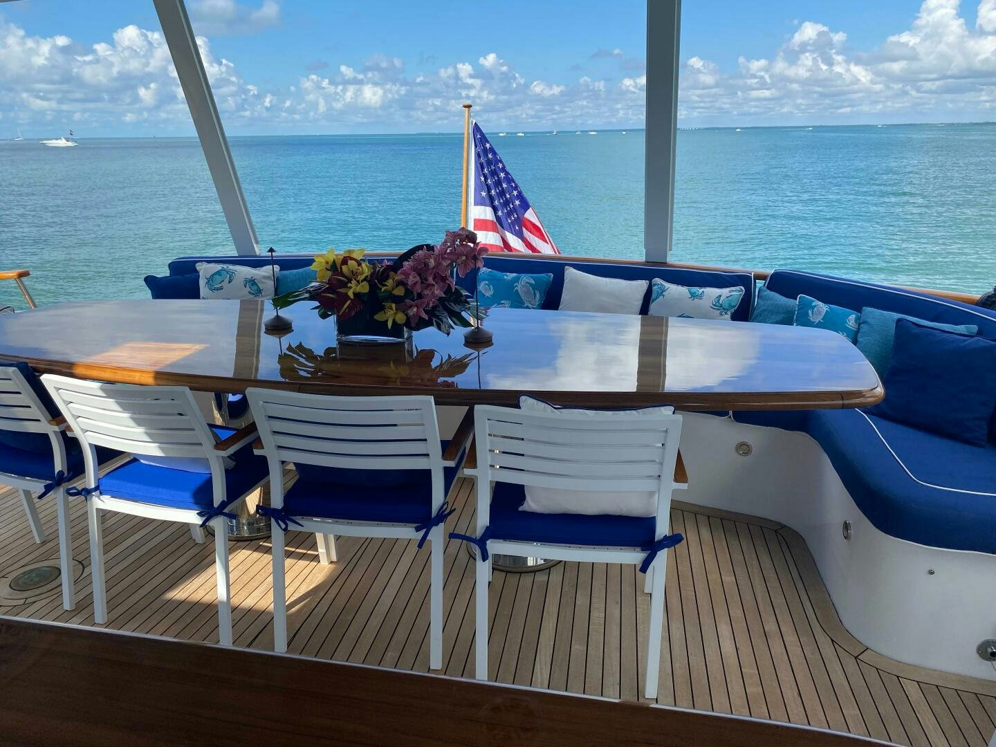 a table with chairs on it next to a body of water aboard PRECIOUS CARGO Yacht for Sale