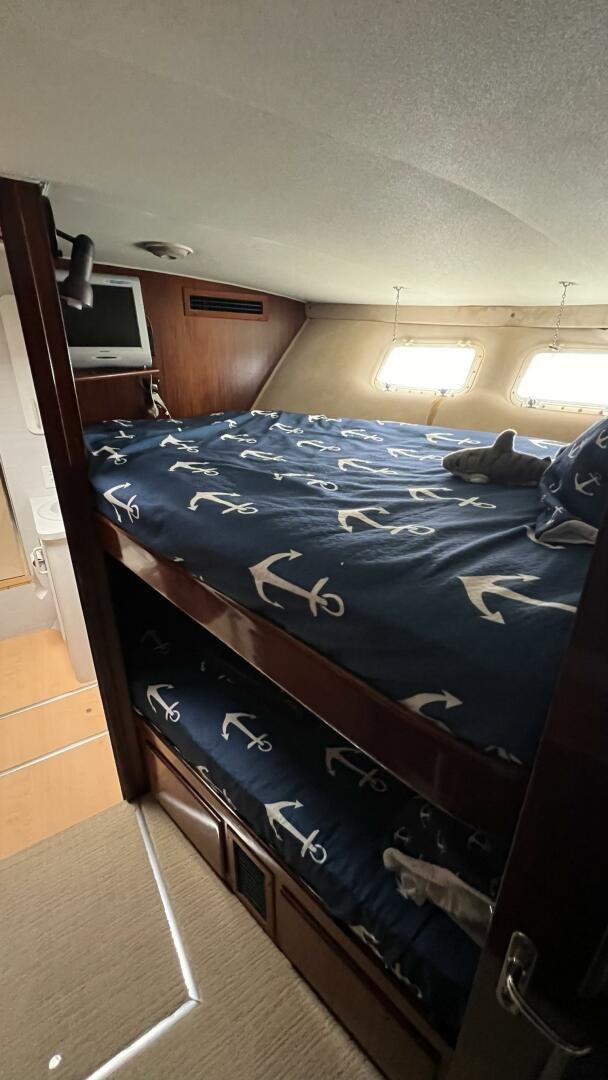 a bed with a blue comforter aboard SEA OWL Yacht for Sale