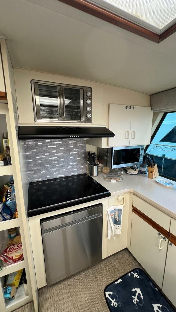 a kitchen with a stove and microwave aboard SEA OWL Yacht for Sale