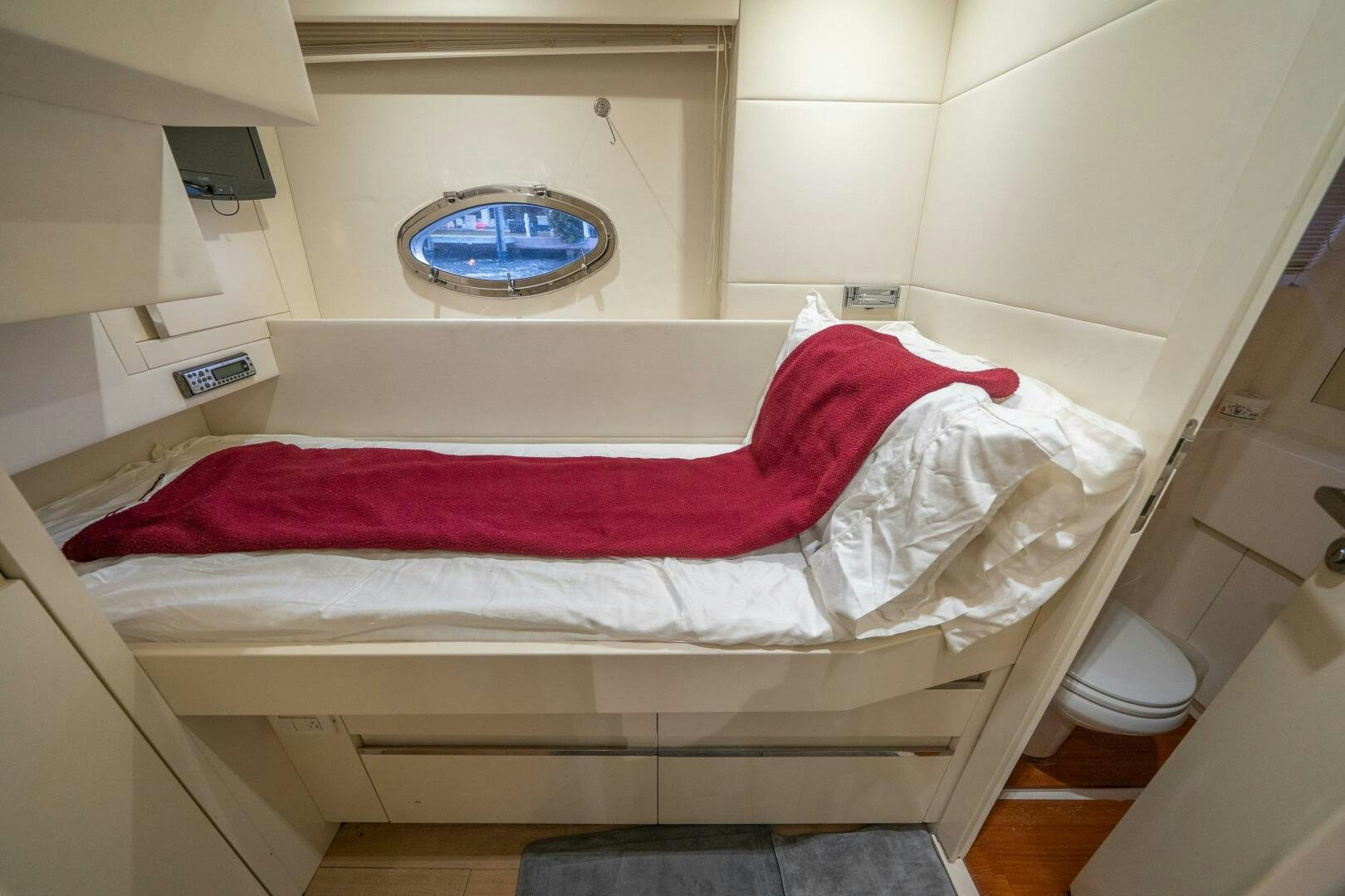 a bed with red sheets aboard INCOGNITO Yacht for Sale