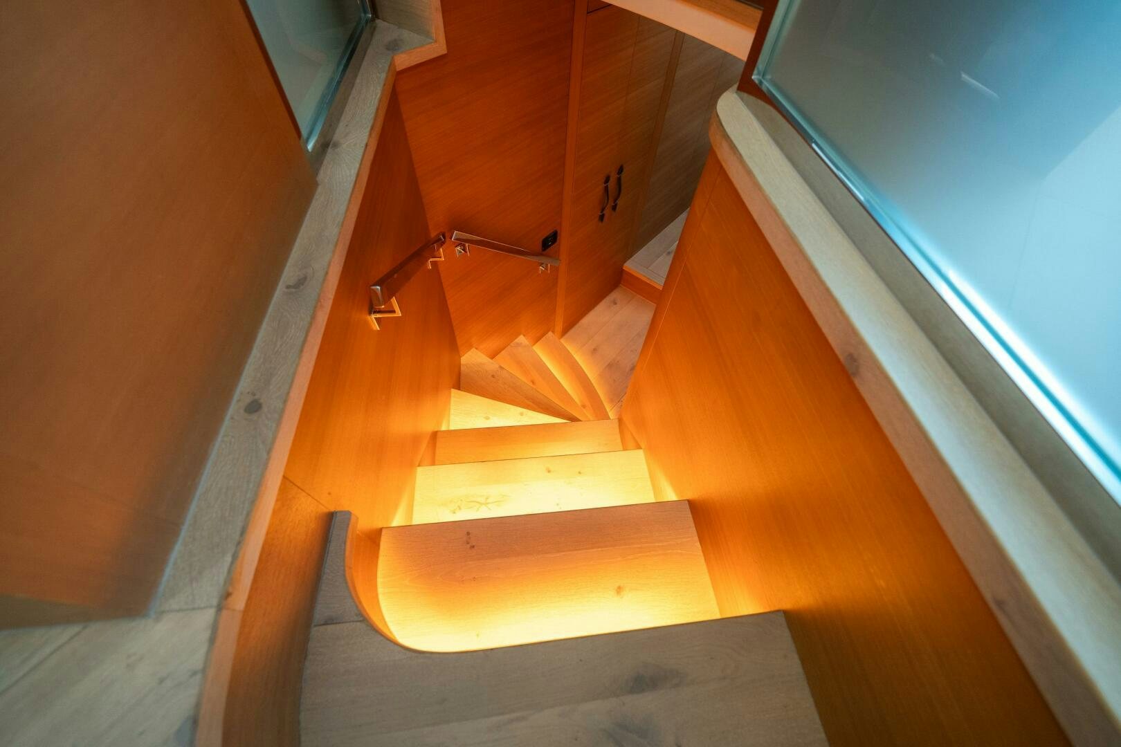 a wooden staircase with a metal railing aboard INCOGNITO Yacht for Sale