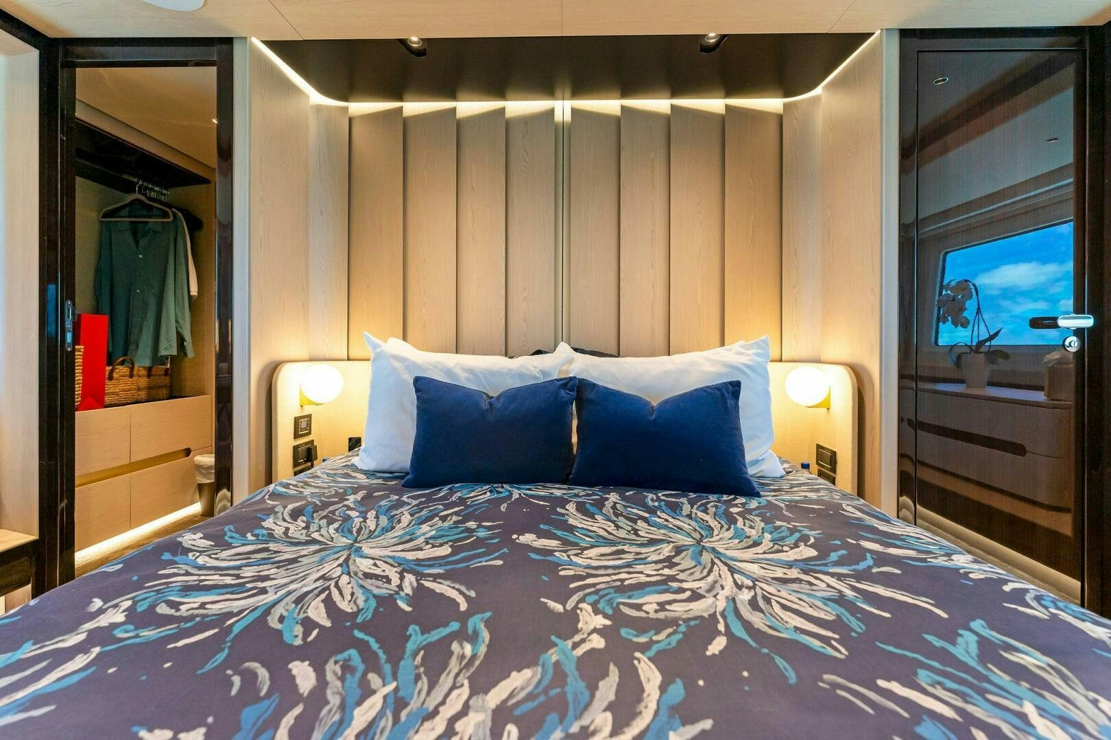 a bed with a blue sheet aboard LIMITLESS Yacht for Sale